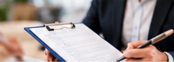 Consultant reviewing a practice assessment on a clipboard